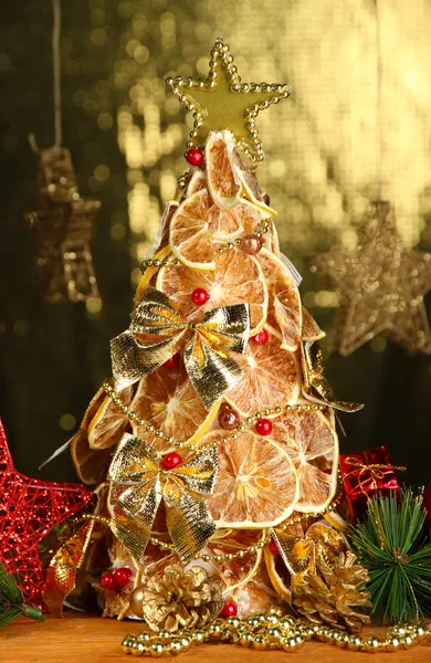 Красивая елка из сухих лимонов с декором, на фоне блеска — стоковое фото