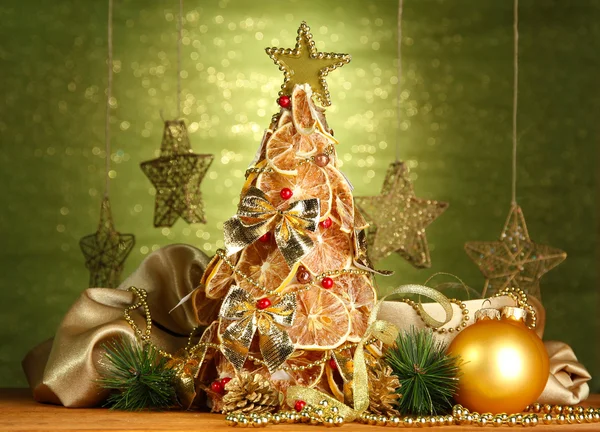 Vackra julgran torra citroner med inredning, på shine grön bakgrund — Stockfoto