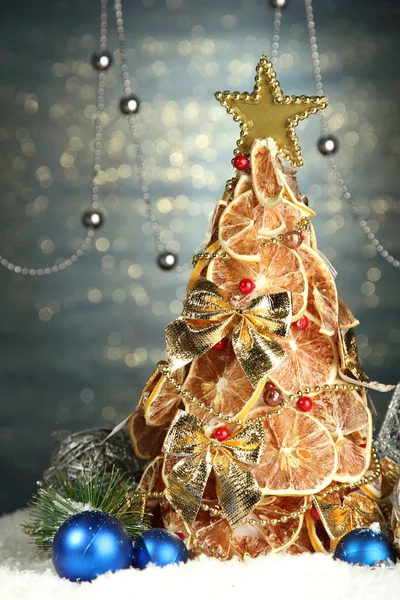 Prachtige Kerstboom van droge citroenen met decor, op glans blauwe achtergrond — Stockfoto