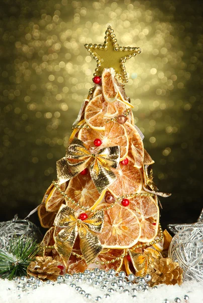 Schöner Weihnachtsbaum aus trockenen Zitronen mit Dekor, auf glänzendem Hintergrund — Stockfoto