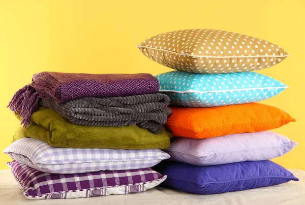 Hills colorful pillows and plaids on yellow background — Stock Photo, Image