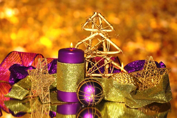 Рождественская композиция со свечами и украшениями в фиолетовых и золотых тонах — стоковое фото
