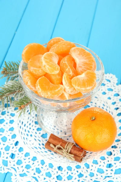 Tasty mandarine's slices in glass bowl on blue background — Stock Photo, Image