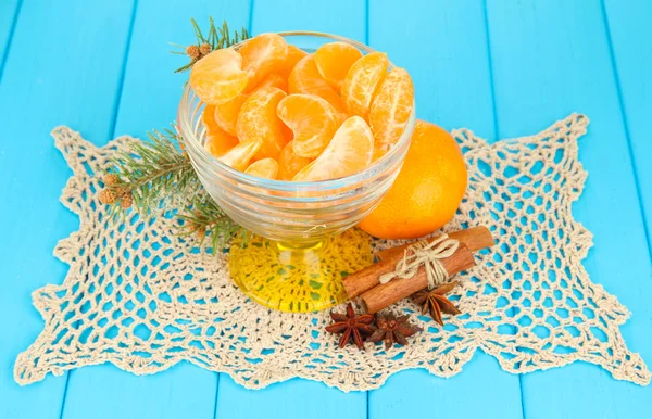 Plastry smaczny mandaryny w szklanej misce na niebieskim tle — Zdjęcie stockowe