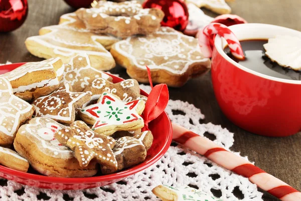 Рождественские угощения на тарелке и чашка кофе на деревянном столе крупным планом — стоковое фото