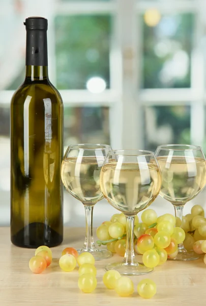 Witte wijn in glas met fles op achtergrond van venster — Stockfoto