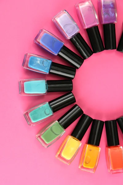 Group of bright nail polishes, on pink background — Stock Photo, Image