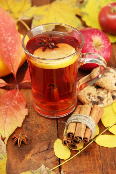 Tasse de thé chaud et feuilles d'automne, sur fond brun — Photo