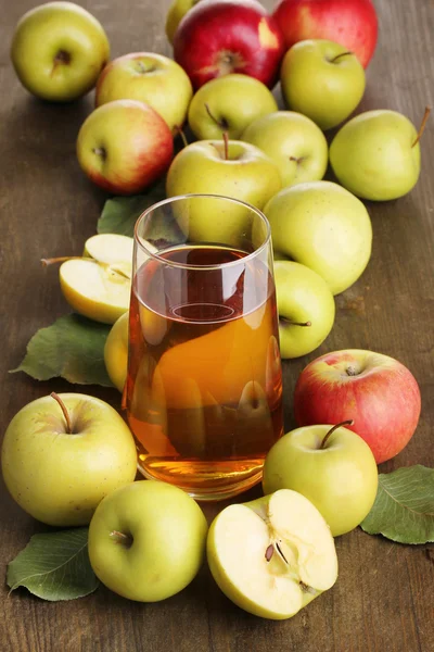 Useful apple juice with apples around on wooden table — Stock Photo, Image