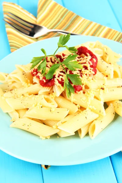 Plato de pasta Rigatoni con salsa de tomate sobre mesa de madera azul de cerca —  Fotos de Stock