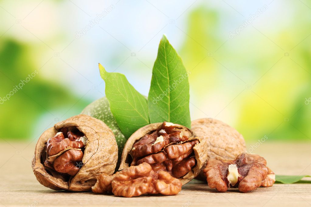 walnuts with green leaves, on green background