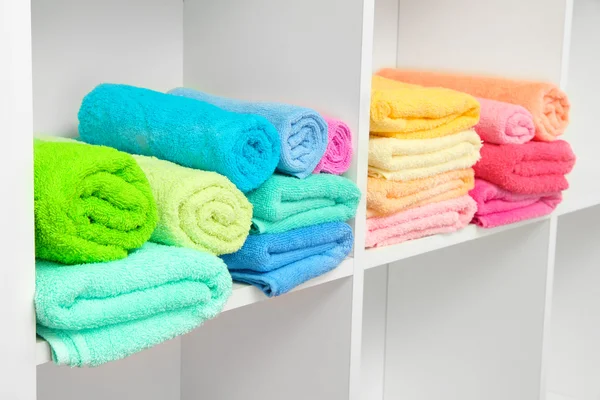 Colorful towels on shelves in bathroom — Stock Photo, Image
