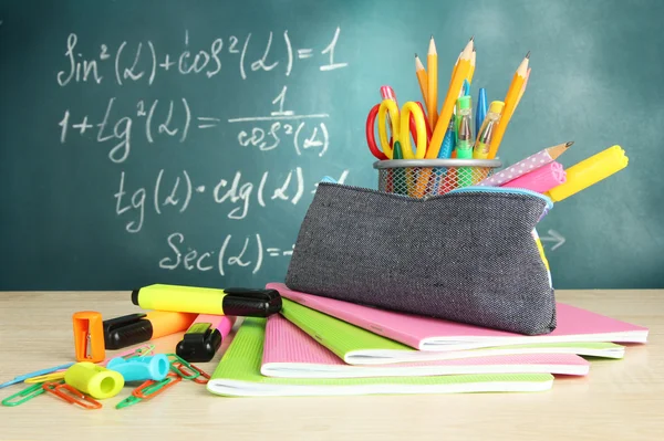Back to school - blackboard with pencil-box and school equipment on table — Stock Photo, Image
