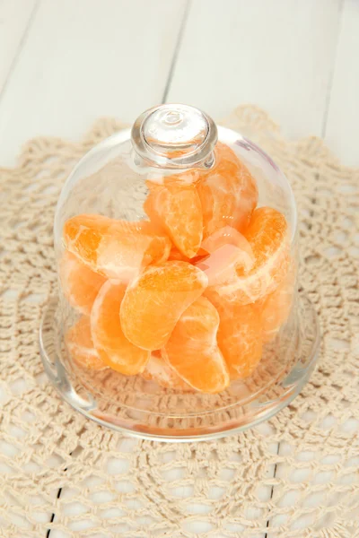 Mandarino sul piattino sotto copertura di vetro su sfondo chiaro — Foto Stock