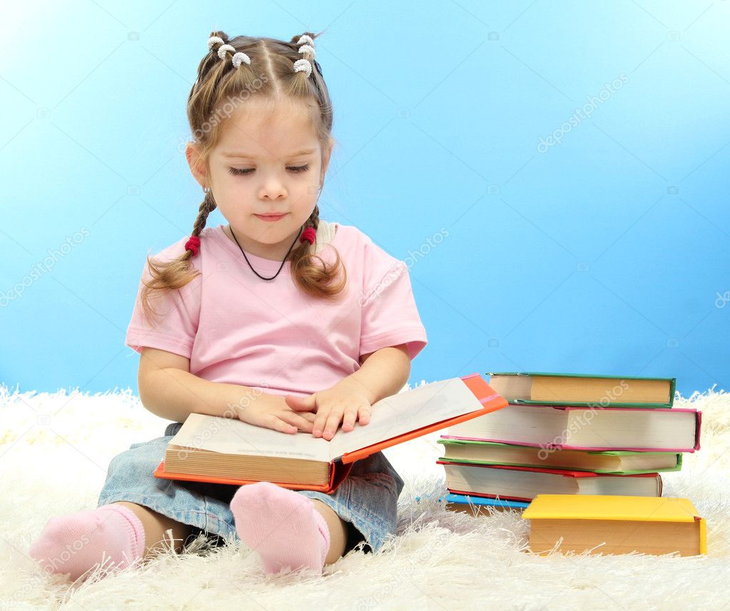 cute little girl with colorful books, on blue background