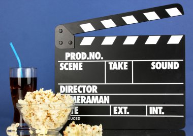 Film Klaket, cola ve mavi arka plan üzerinde patlamış mısır