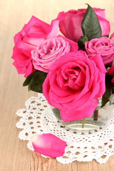 Hermosas rosas rosadas en jarrón en la mesa de madera de cerca — Foto de Stock