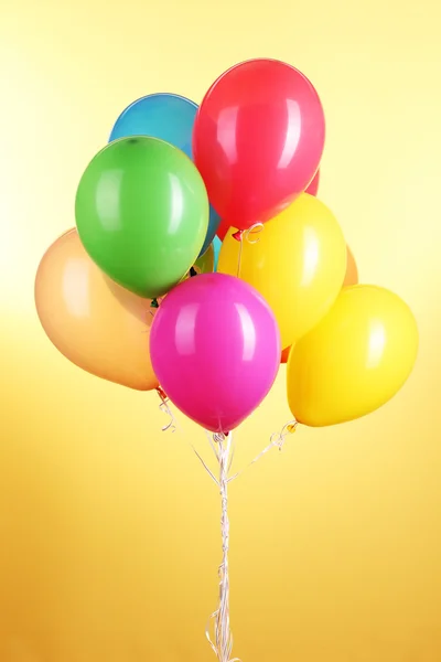 Colorful balloons on yellow background — Stock Photo, Image