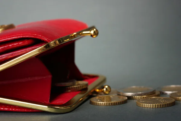 Billetera roja femenina con monedas sobre fondo gris —  Fotos de Stock