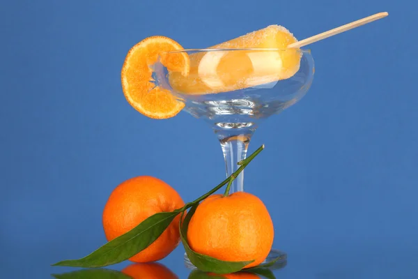 Zumo de fruta amarilla hielo en jarrón sobre fondo azul —  Fotos de Stock