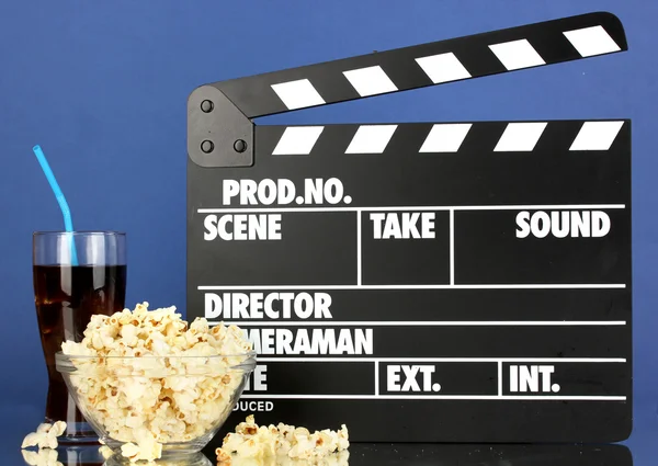 Film clapperboard, cola et pop-corn sur fond bleu — Photo