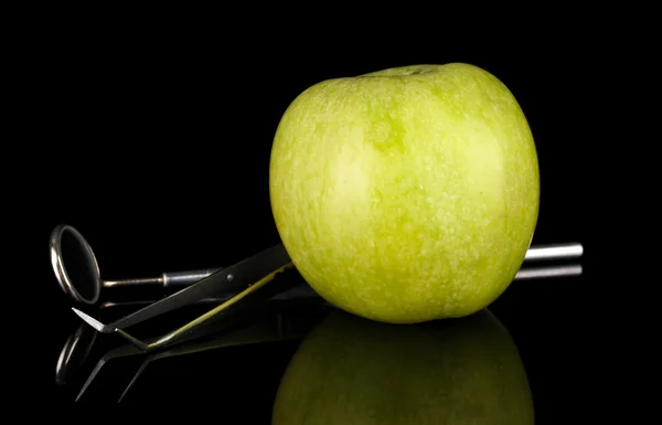 Manzana verde y herramientas dentales aisladas en negro —  Fotos de Stock