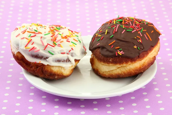 Velsmagende donuts på farveplade på farve baggrund - Stock-foto