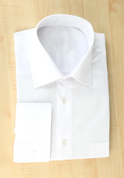 Nueva camisa de hombre blanco sobre fondo de madera —  Fotos de Stock