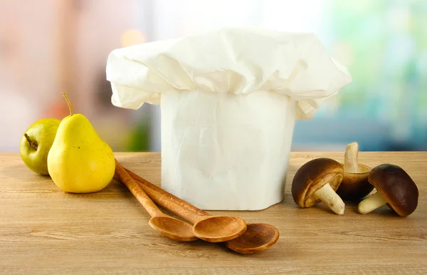 Koksmuts met lepels op tafel in de keuken — Stockfoto