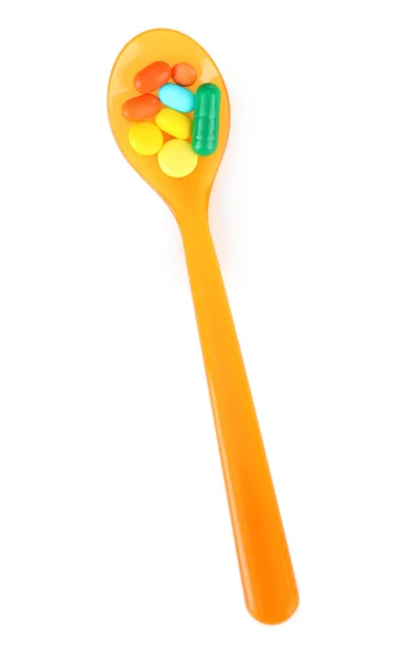 Plastic spoon with color pills, isolated on white — Stock Photo, Image