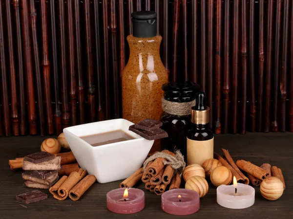 Ustawienie uzdrowiskowej czekolady na tle bambusa drewniany stół z odbiciem — Zdjęcie stockowe
