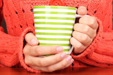 yakın çekim sıcak bir fincan tutan eller iç