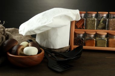 Şef'in şapkası ve kitchenwear tabloda gri arka plan üzerinde kompozisyonu