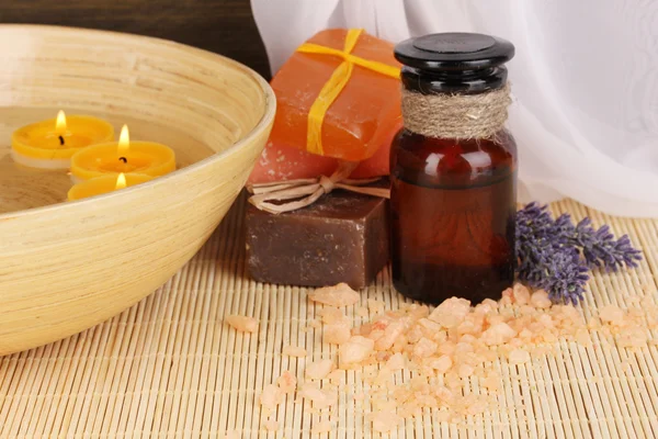 Bottle with aromatic oils with accessories for relaxation close-up on wooden table on wooden background — Stock Photo, Image