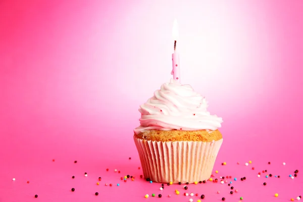 Välsmakande födelsedag cupcake med ljus, på rosa bakgrund — Stock fotografie