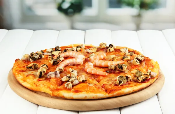 Pyszną pizzę z owocami morza na stole na jasnym tle — Zdjęcie stockowe