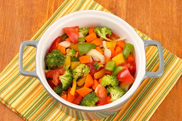 Zeleninový guláš v šedé hrnci na barevný ubrousek na dřevěné pozadí — Stock fotografie
