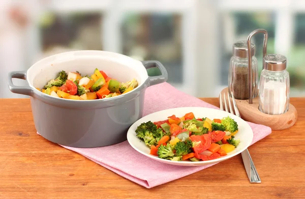 Gemüseeintopf im grauen Topf auf Holztisch vor hellem Hintergrund — Stockfoto