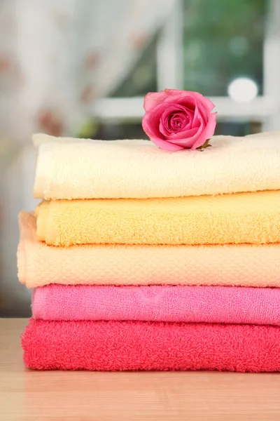 Stack of towels with fragrant flower on window background — Stock Photo, Image