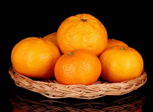 Sabrosas mandarinas en estera de mimbre aislada en negro —  Fotos de Stock