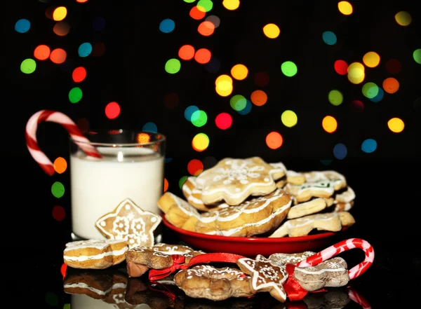Рождественские угощения со стаканом молока на фоне рождественских огней — стоковое фото