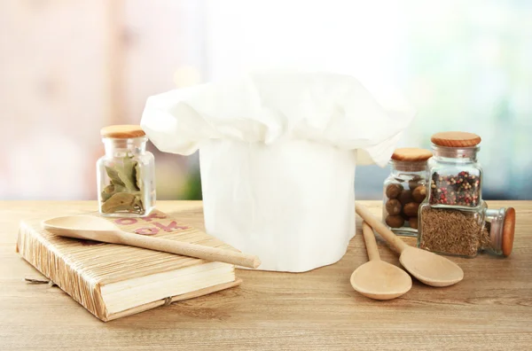 Koksmuts met lepels op tafel in de keuken — Stockfoto