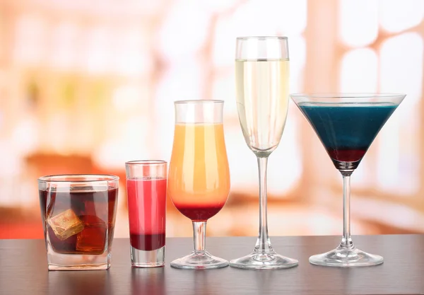 Several glasses of different drinks on bright background — Stock Photo, Image