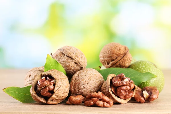 Walnuts with green leaves, on green background — Stock Photo, Image