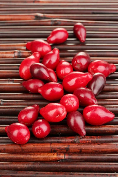 Fresh cornel berries on bamboo mat — Stock Photo, Image