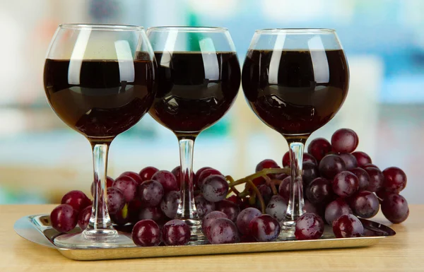 Rotwein im Glas auf Salver auf Zimmerhintergrund — Stockfoto