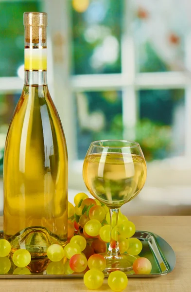 Vinho branco em vidro com garrafa em salver no fundo da janela — Fotografia de Stock