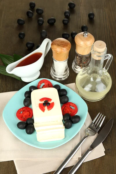 Feta cheese on plate decorated with spices and oil on wooden table close-up — Stock Photo, Image