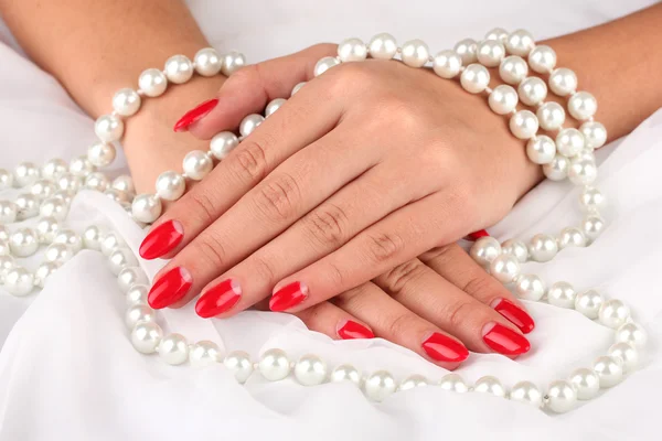 Female hands holding beads on color background — Stock Photo, Image