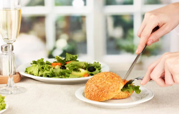 Vrouwelijke hand met diner op lichte achtergrond — Stockfoto